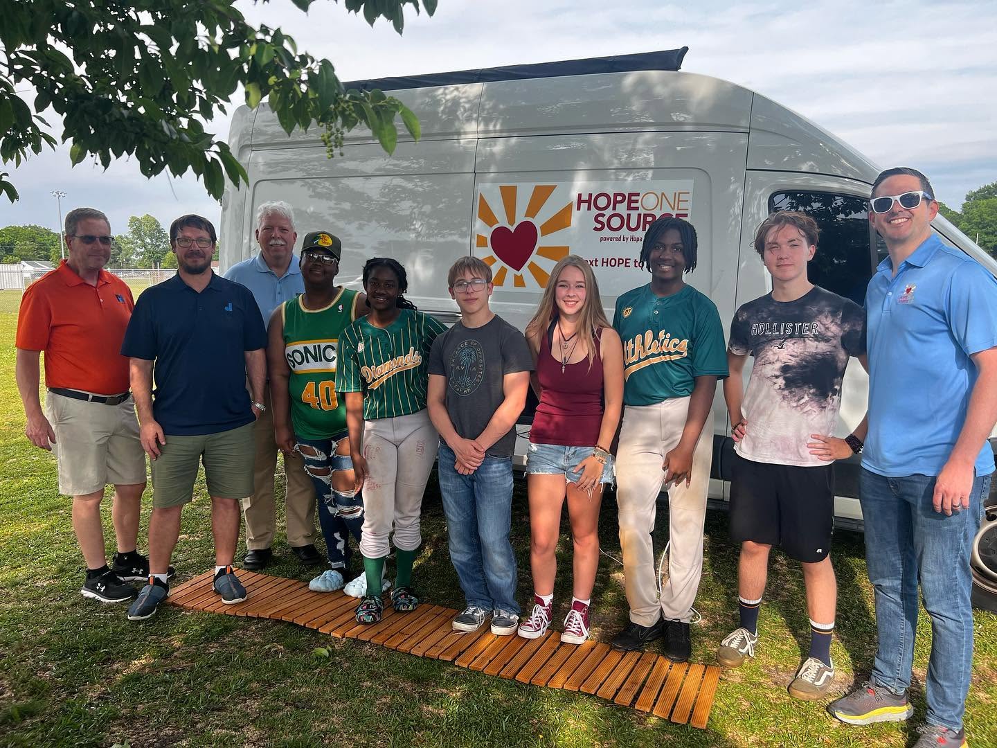 Community members and partners gathered beside the H1S outreach van at a Portsmouth STEM event.